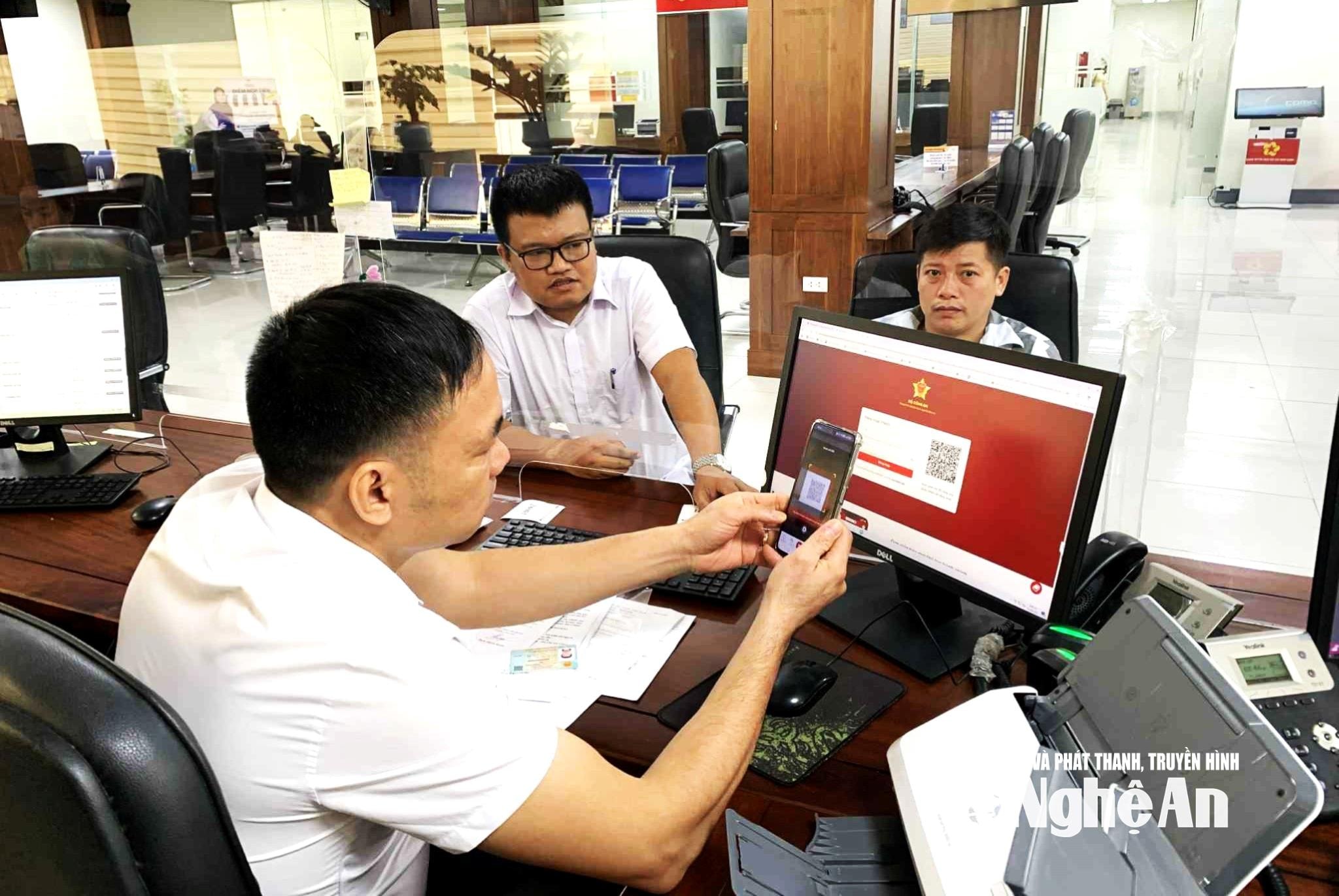 Công chức ngành Nông nghiệp và Môi trường nghệ An tiếp nhận hồ sơ và hướng dẫn người dân thực hiện số hóa trên các hồ sơ, tài liệu giấy liên quan để chuyển đổi hồ sơ điện tử. Ảnh: Hoàng Vĩnh
