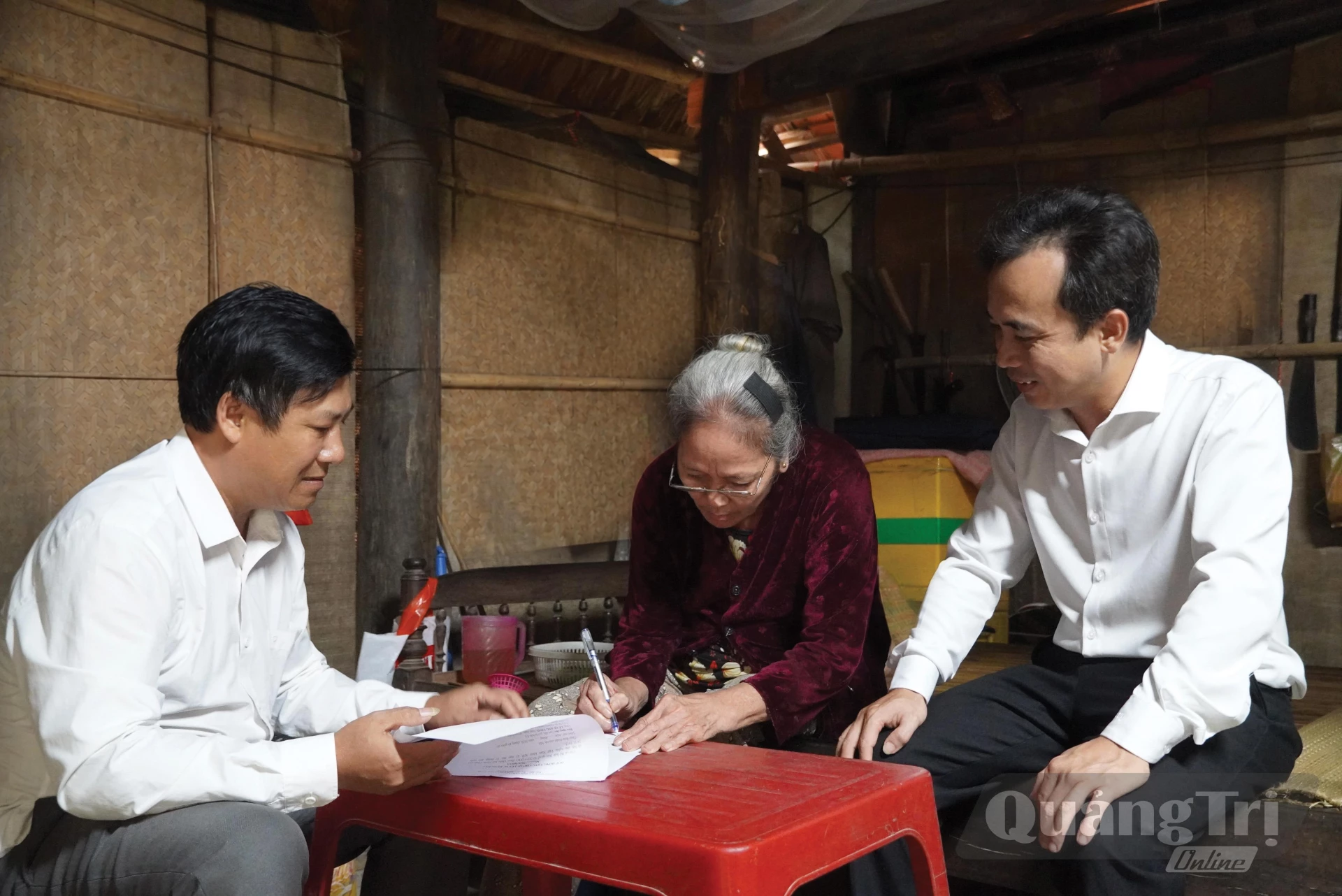 Cán bộ Trung tâm Phục vụ hành chính công xã Tuyên Hóa mang hồ sơ đến tận nhà hỗ trợ bà Phạm Thị Điền, ở thôn Lạc Sơn - Ảnh: H.L