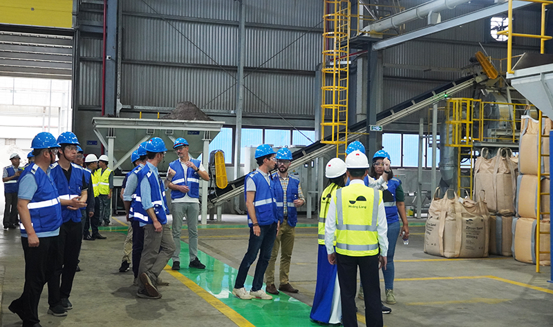 Nhân viên Công ty Hoàng Long hướng dẫn các chuyên gia quốc tế ZIA thăm nhà máy chế biến tiitan của Công ty Hoàng Long.