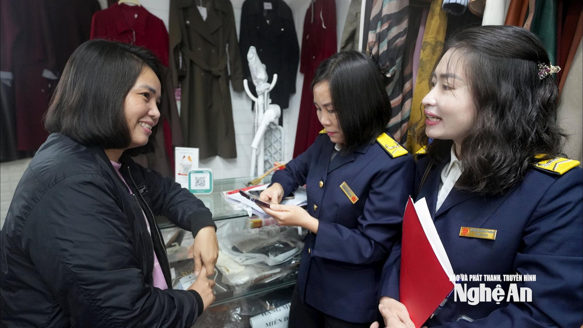 Cán bộ Thuế tỉnh Nghệ An trao đổi, hướng dẫn hộ kinh doanh các bước thực hiện chuyển đổi phương pháp nộp thuế. Ảnh: Quang An
